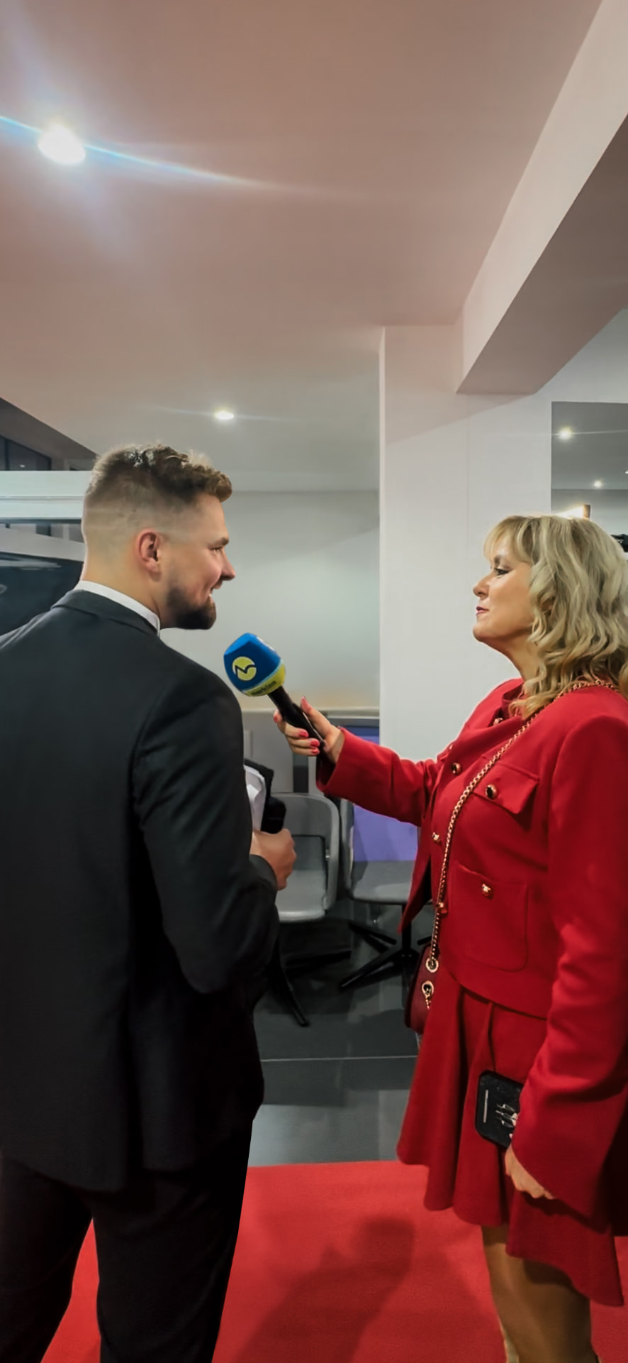 Ján Mrázik počas mediálnych povinností, odpovedá na rozhovor so žurnalistkou s mikrofónom